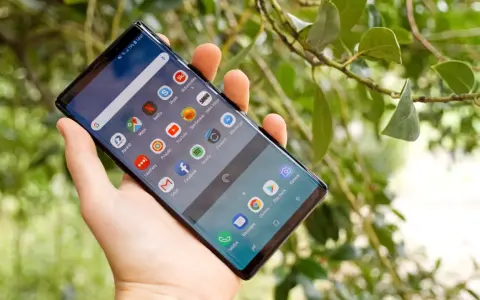 En hand håller en Samsung Galaxy Note 9 med många appar på skärmen, bland annat BankID och Spotify.