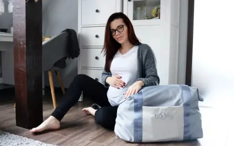 Gotowa na poród! Ciężarna kobieta z torbą, czyli wyprawka do szpitala czeka.