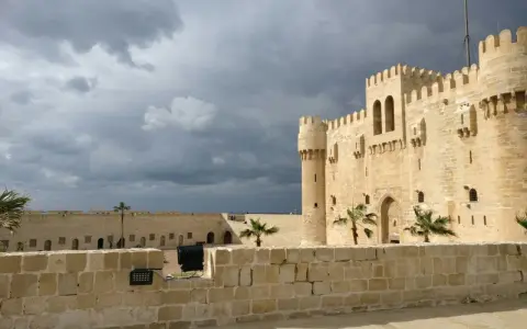 Die Zitadelle von Qaitbay in Aleksandria, Ägypten, ragt unter einem dramatischen Himmel auf.