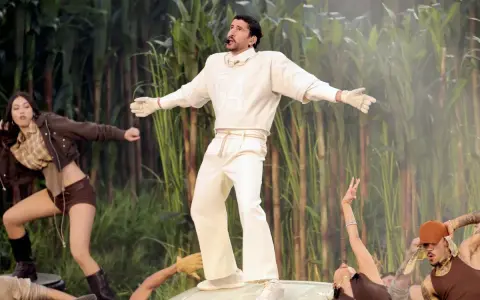 Bad Bunny's iconic bad bunny super bowl outfit, a white ensemble with a "64" on the sweatshirt, stands out against a backdrop of tall green stalks.