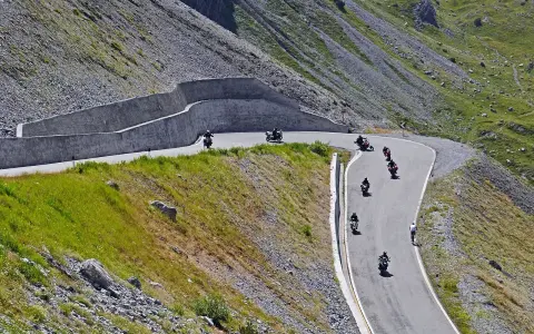 Motocykliści przemierzają kręte trasy w górach, ciesząc się wolnością i pięknymi widokami. To idealne miejsce na odkrywanie polskich tras motocyklowych.