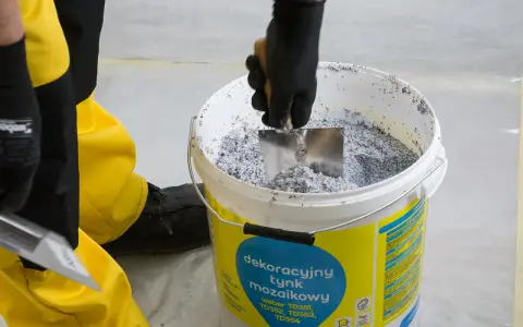 Mieszanie dekoracyjnego tynku mozaikowego w wiadrze. To pierwszy krok, jak zrobić tynk mozaikowy, by uzyskać efektowną elewację.