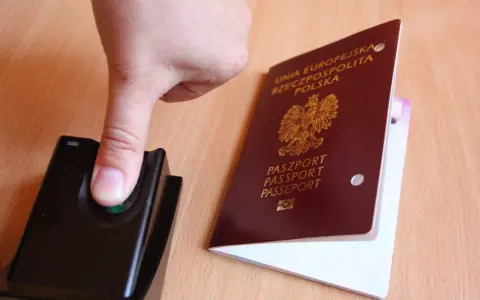 Palec na czytniku linii papilarnych obok polskiego paszportu. To pokazuje, ile ważny jest paszport w dzisiejszych czasach.