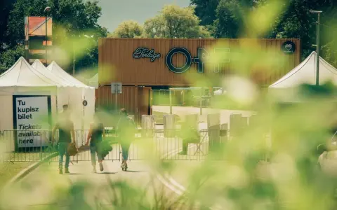 Ludzie idą po bilety na OFF festival. W tle widać logotyp festiwalu.