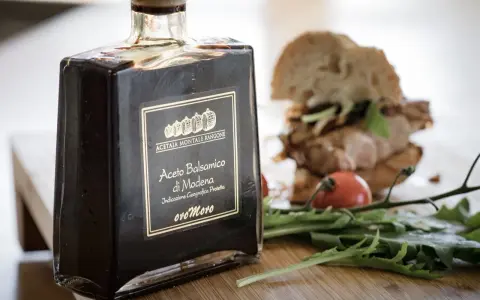 Butelka octu balsamicznego z Modeny obok kanapki i rukoli. Czy ocet balsamiczny jest zdrowy?