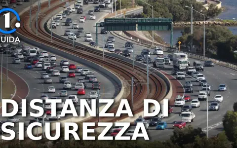 Traffico intenso su un'autostrada con molte auto e camion. Il testo "Distanza di Sicurezza" e "Guida" suggerisce l'importanza di rispettare le norme, come l'art. 149 cds.