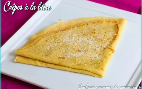 Crêpes à la bière, dorées et saupoudrées de sucre, sur une assiette blanche. Un délice gourmand !