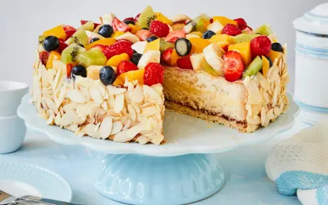 Ein bunter Obstkuchen, verziert mit Mandelsplittern, inspiriert zu neuen obstkuchen rezepten.