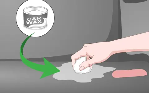 A hand applies car wax to a gray surface, showing how to remove scratches from clear plastic.