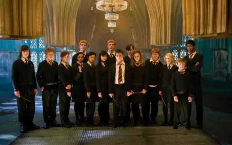 Grupa uczniów z domu Hufflepuff, w tym Harry Potter, stoi w eleganckiej sali.