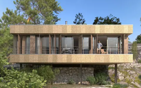 Casa moderna con fachada texturizada y grandes ventanales. Un hombre en el balcón. ¿Cuánto cuesta hacerse una casa teniendo el terreno?