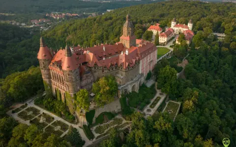 Zamek Książ otoczony zielenią, z pięknymi ogrodami i widokiem na okoliczne góry. To wspaniałe miejsce, by odkrywać atrakcje Gór Sowich.