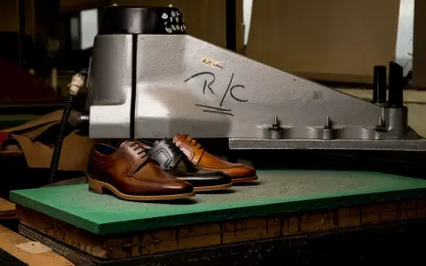 Scarpe eleganti in pelle marrone e nera, pronte per essere lavorate per ammorbidire la pelle.