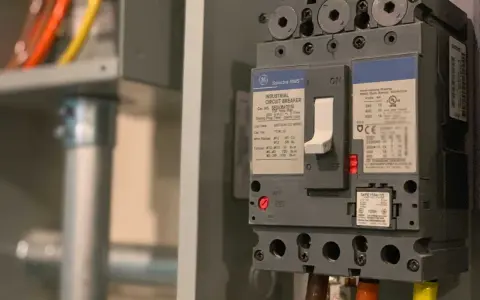 En industriell automatsäkring, redo att installera jordfelsbrytare. Kablar i orange, gult och grönt syns.