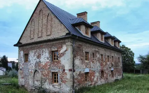 Stary budynek w Bieczu, zniszczony tynk, ceglane ściany, okna z drewnianymi ramami. Jedna z bieckich atrakcji, czekająca na renowację.