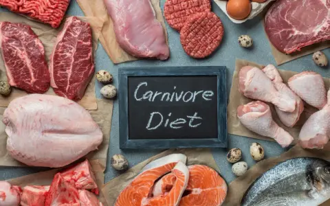 Różnorodne mięsa, ryby i jaja na stole. Tabliczka z napisem "Carnivore Diet" sugeruje potencjalne dieta karniwora efekty.