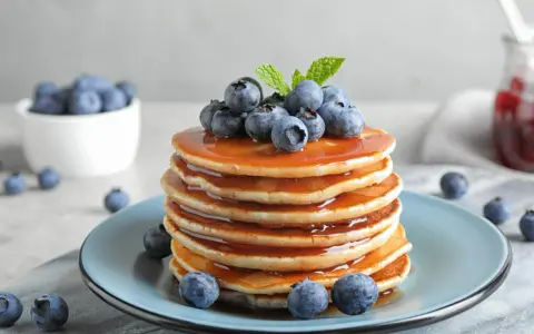 Pyszny stos naleśników z syropem i borówkami, idealny na śniadanie. Ten przepis na pancake zachwyci każdego!