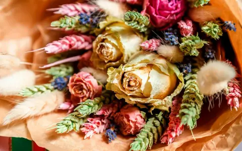 En vacker bukett med torkade blommor, som rosor och lavendel, visar hur torkar man blommor för att bevara deras skönhet.
