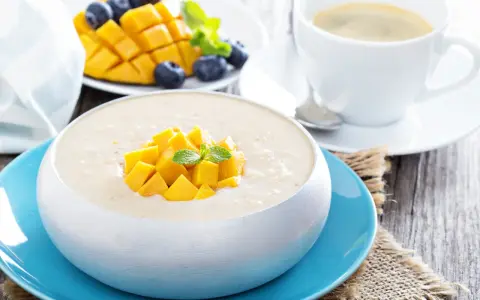 Pyszny deser z mango, jagodami i kawą. Ten mango smak to idealny początek dnia.