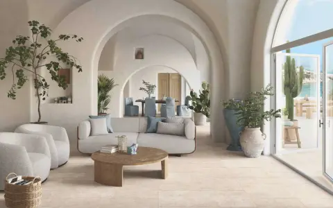 Un salon lumineux avec des arches, des plantes et un canapé confortable. Le sol en carrelage clair est idéal pour ce style méditerranéen. Quel revêtement de sol choisir ?