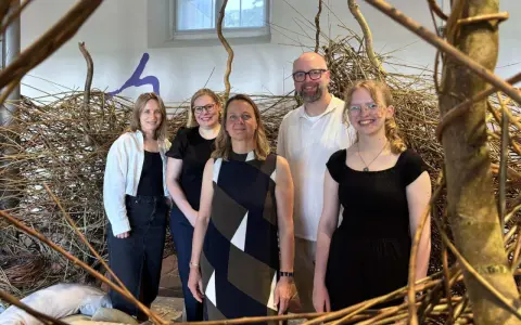 Fünf Personen stehen vor einer Installation aus Ästen. Sie sind Teil des museumsnacht programm.