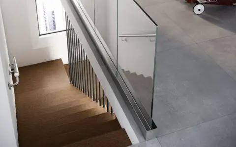 Scale moderne in legno e vetro con corrimano in metallo. Le scale misurano l'eleganza di un design minimalista.