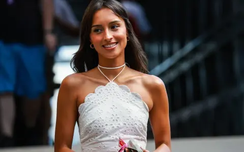 La presunta **Charles Leclerc fidanzata**, Charlotte Siné, sorride con un top bianco ricamato.