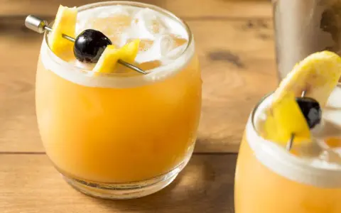 Zwei erfrischende Cocktails mit Zitronenzeste und Kirsche, perfekt für die Liste der 10 beliebtesten Cocktails.