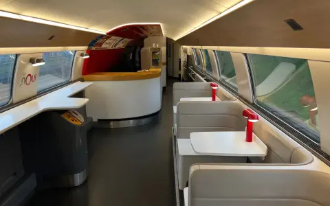 Interior of a TGV train carriage, ready for a journey from Amsterdam to Bordeaux. Booth seating and a bar area await passengers.