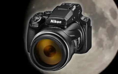 Czarny aparat Nikon Coolpix P1000 z żółtym obiektywem na tle księżyca. Idealny do fotografowania odległych obiektów.