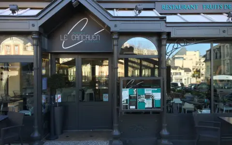 La façade de la meilleure brasserie Saint-Malo, "Le Cancaluen", avec son enseigne élégante et ses grandes vitrines reflétant la ville.
