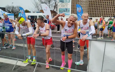Marcin Konieczny i inni biegacze w biało-czerwonych strojach czekają na start.
