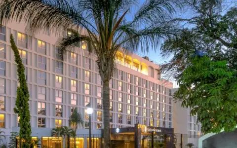 Elegancki hotel w Lusace, stolicy Zambii, otoczony bujną zielenią i palmami.