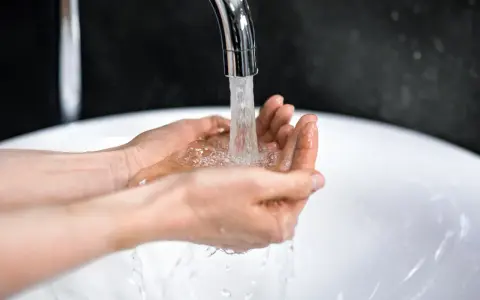 Dłonie łapią strumień wody z kranu. Zastanawiasz się, ile kosztuje kubik wody?