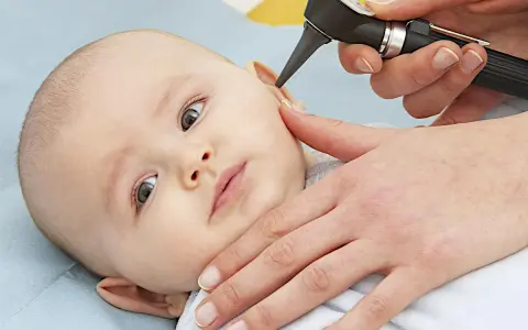 Esame dell'orecchio di un neonato per diagnosticare un'otite.