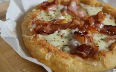 Pyszna pizza keto z chrupiącym boczkiem i ciągnącym serem, idealna na niskowęglowodanową ucztę.
