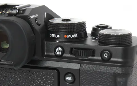 Część aparatu Fujifilm xt3 z pokrętłem wyboru trybu "STILL" i "MOVIE", przyciskiem "AF ON" i pokrętłem sterującym.