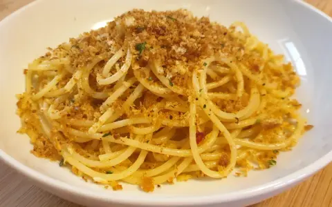 Spaghetti conditi con aglio, olio e abbondante pasta con la mollica croccante.