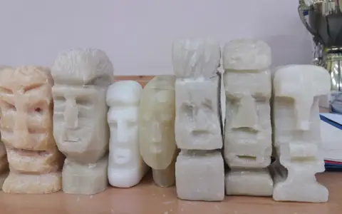 Rząd rzeźbionych w mydle figurek w kształcie głów Moai.