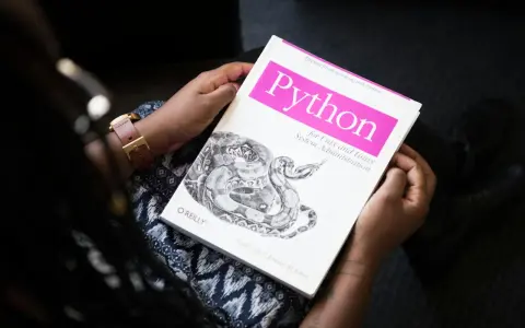 Osoba trzyma książkę "Python for Unix and Linux System Administration". To świetna lektura do testowania oprogramowania i nauki Pythona.
