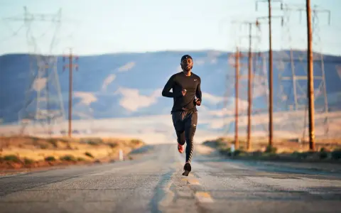 Un uomo corre su una strada deserta, circondato da tralicci dell'alta tensione. La corsa come fuga dalla depressione.