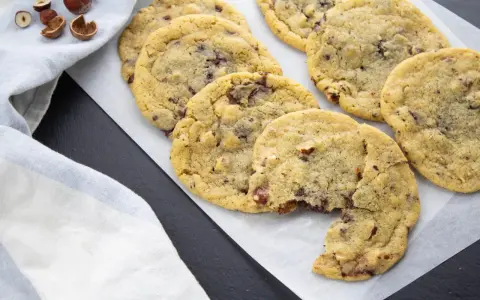 Gros plan sur des cookies aux pépites de chocolat et noisettes, dont le beurre fondu a donné une texture parfaite. Un délice !