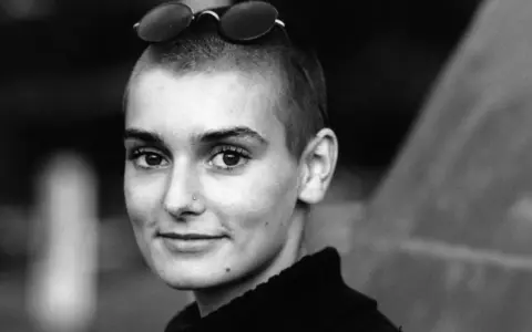 Sinéad O'Connor mit Sonnenbrille auf dem Kopf, ein nachdenklicher Blick. Ihr ikonischer Titel "Nothing Compares 2 U" hallt nach.