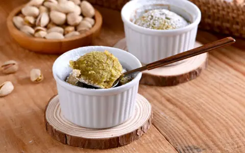 Un delicioso coulant de pistacho, recién horneado y espolvoreado con azúcar glas. ¡Una delicia para los sentidos!