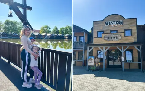 Rodzina na tle Western Camp z domkami nad wodą i recepcją.