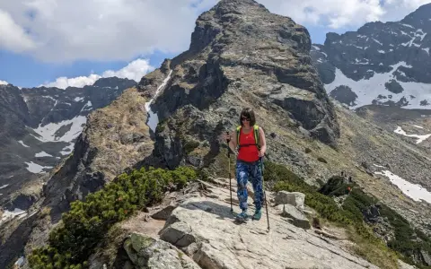 Kobieta z kijkami trekkingowymi na skalistej ścieżce w Tatrach. Czy to szlak dla każdego? Kościelec czeka!