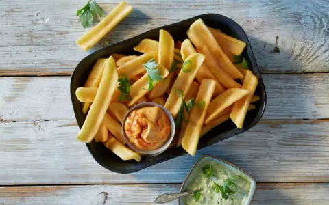 En skål med gyllene pommes frites, perfekt för att doppa i den krämiga såsen till pommes.