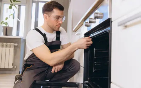 Un technicien vérifie la hauteur et l'étanchéité d'un four encastrable.
