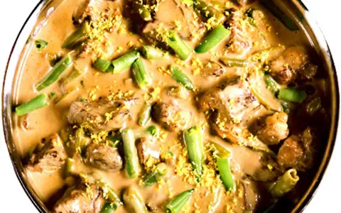 En krämig biff stroganoff med möra köttbitar och gröna bönor, toppad med gul strössel.