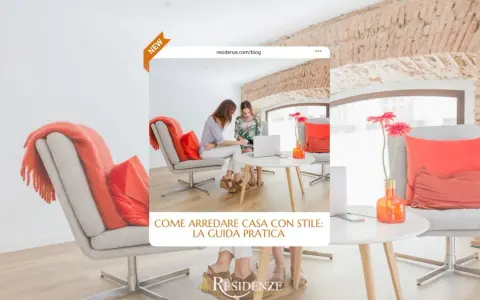 Due donne discutono idee per arredare casa in un salotto moderno con poltrone grigie e cuscini arancioni.